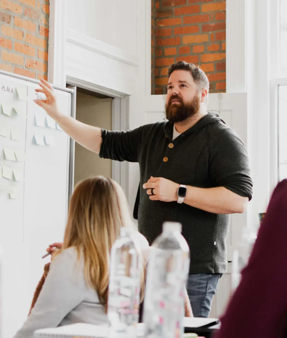 Ryan Magada of Brave Little Beast pointing at a whiteboard during a brand strategy session